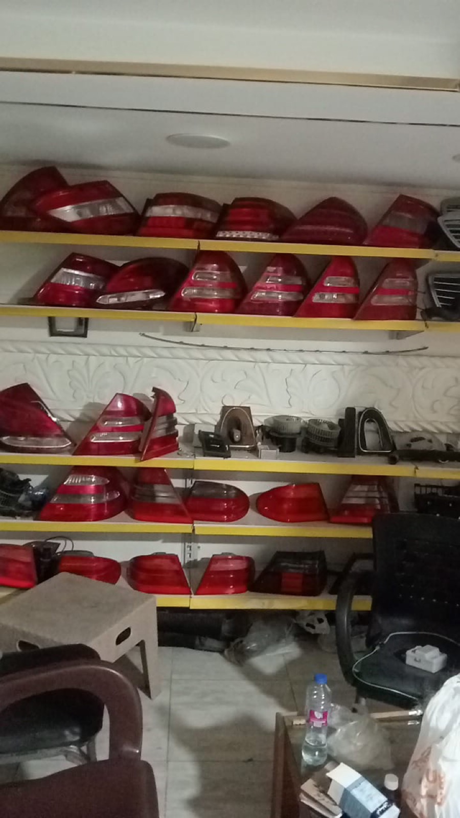 Mercedes rims, headlights, and interior parts organized in the workshop